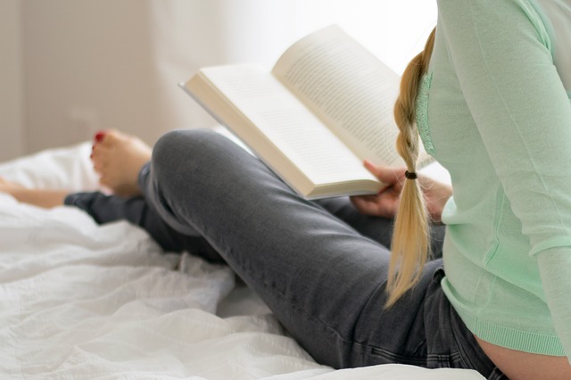 žena při čtení knihy v posteli